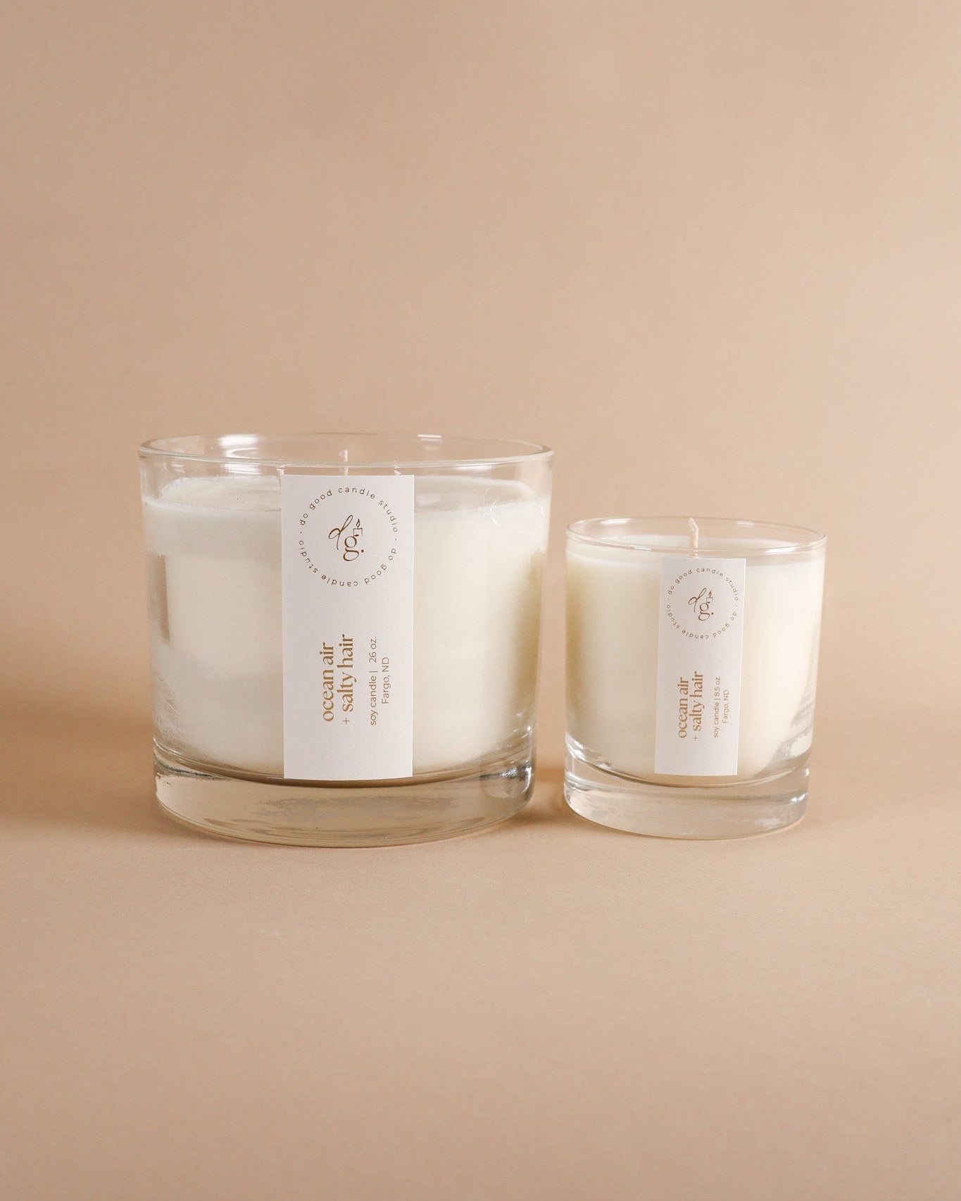 ocean air + salty hair triple wick candle and regular 8.5 oz candle on beigh background
