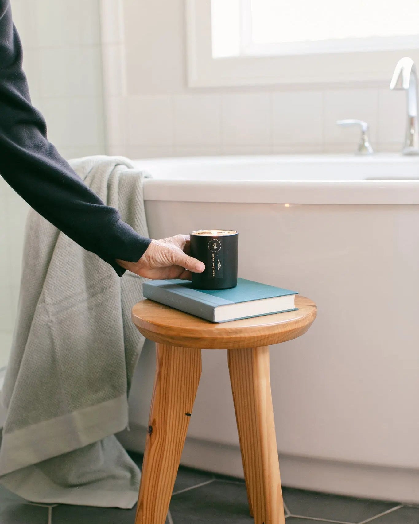 Woman placing a candle by a bathtub