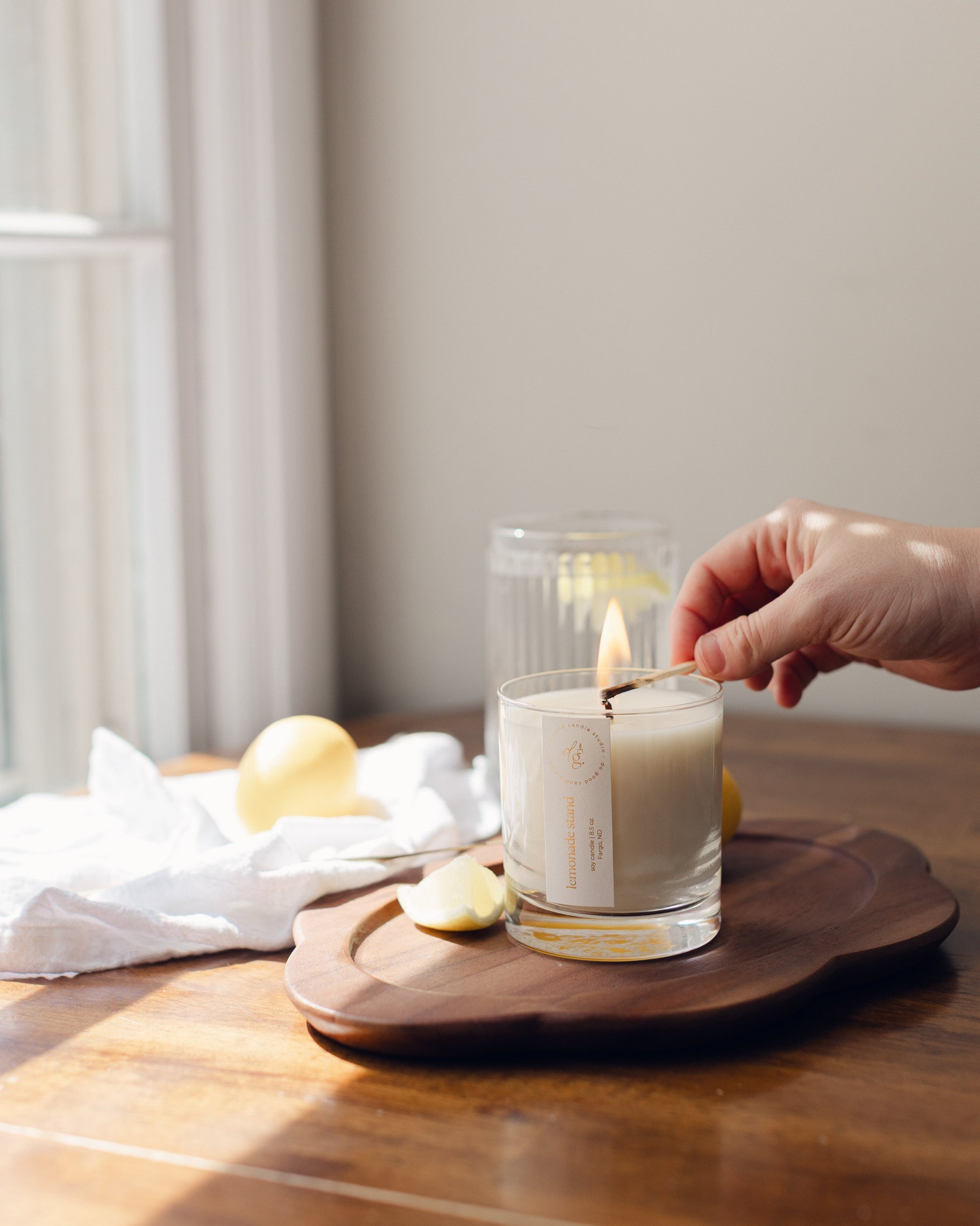 hand lighting lemonade stand candle