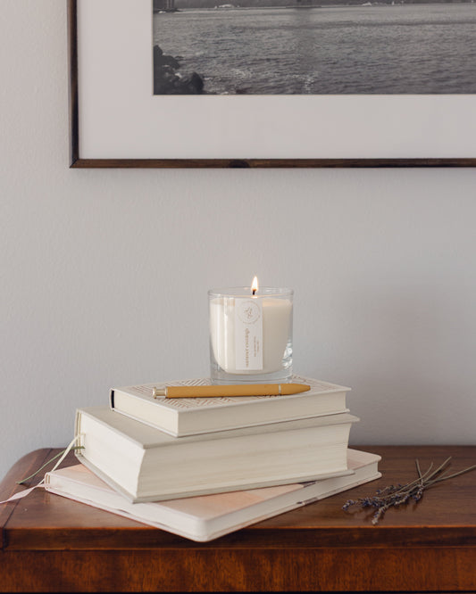 summer evenings candle burning on a stack of books on a console table