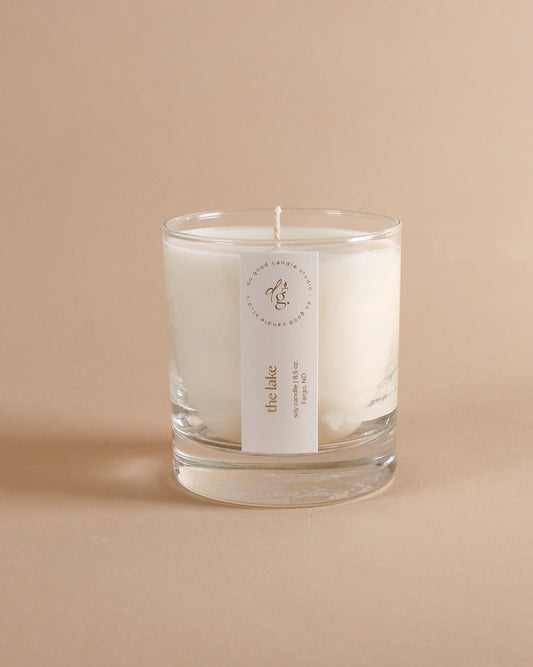 The Lake 85 oz candle on beige background